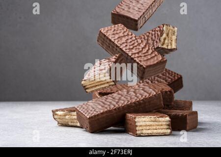 Barretta di cioccolato che cade, mucchio di wafer Foto Stock
