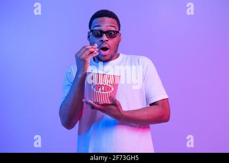 Ritratto di guy afro-americano scioccato in 3D occhiali mangiare Popcorn Foto Stock