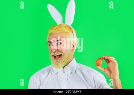 Buona Pasqua. Uomo bearned in orecchie conigliate con uovo di Pasqua. Coniglio uomo. Primavera. Caccia alle uova. Foto Stock