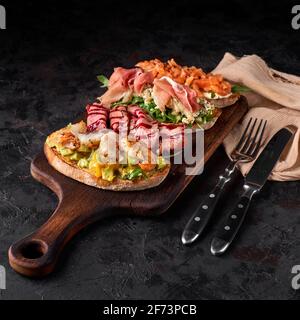 tavola di legno con gustose bruschette fresche sul tavolo Foto Stock