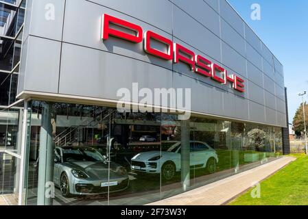 Concessionaria Porsche a Colchester, Essex, Regno Unito. Marchio Porsche, logo, simbolo. Scritte stilizzate sull'edificio dello showroom. Giorno luminoso e soleggiato Foto Stock