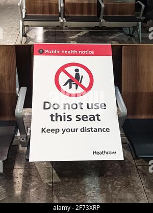 Londra, Inghilterra, 15 marzo 2021. Partenze all'aeroporto internazionale di Heathrow con segnali laterali che avvertono i passeggeri di mantenere la distanza a causa del COVI Foto Stock