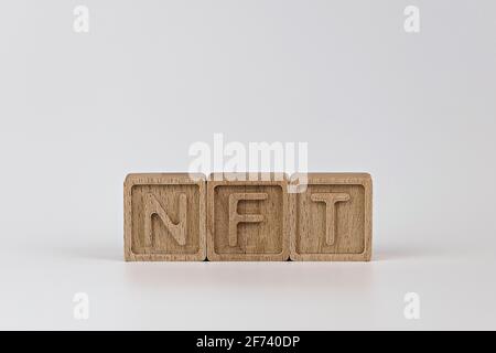 Foto sul tema NFT (token non fungibile). Cubi di legno con l'abbreviazione NFT, su sfondo bianco Foto Stock