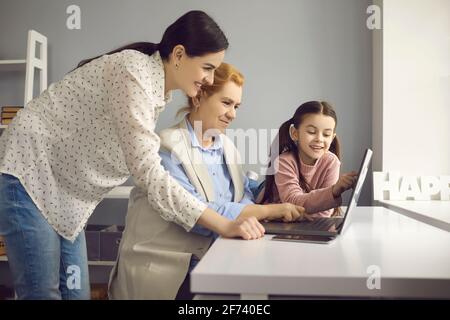 Figlia adulta nipote che insegna la nonna anziana ad usare internet su computer portatile Foto Stock