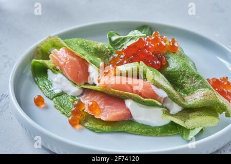 Crepes di spinaci verdi con salmone affumicato, caviale rosso e salsa di yogurt Foto Stock