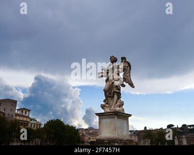 Roma, Italia - 18 agosto 2019: Antica scultura in marmo sul Ponte Sant'Angelo attraverso il fiume Tevere su epico sfondo panoramico del cielo Foto Stock