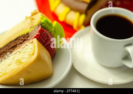 Pezzo della torta Burger, Madeira e torta stratificata di spugna di cioccolato, riempito con glassa ricoperta di glassa morbida e decorazioni di zucchero commestibile, torta i Foto Stock