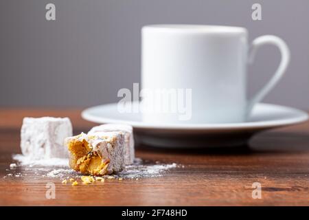 Caffè turco tradizionale servito in tazzine classiche con delizie turche. Sullo sfondo è presente una caffettiera in metallo. Foto Stock