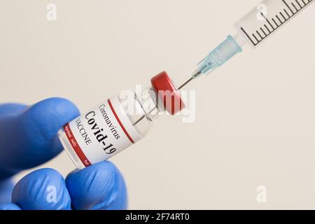 Medico che detiene il vaccino di Coronavirus e siringa che usa per prevenire l'infezione da COVID-19. Foto Stock
