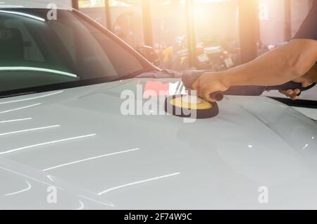 Servizio di automobile operaio maschile lucidatura di vernice automobilistica. Concetto di dettaglio dell'auto. Foto Stock