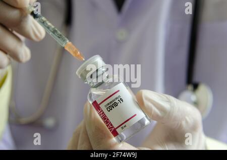 Medico o laborante che contiene una provetta per il vaccino COVID-19 o un vaccino per il coronavirus. Concetto di vaccino del coronavirus Foto Stock