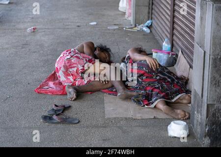 Due senzatetto dormono su un marciapiede in una zona povera, Cebu City, Filippine Foto Stock