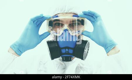 disinfettante professionale che ti guarda attraverso gli occhiali di sicurezza. Foto Stock