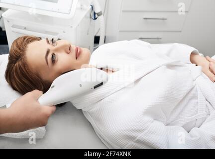 L'estetista rimuove le macchie marroni sulla pelle di una donna nel salone di bellezza. Ringiovanimento della pelle di una bella donna Foto Stock