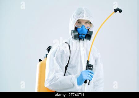 addetti ai servizi di decontaminazione che indossano dispositivi di protezione individuale, disinfettante a spruzzo. Foto Stock