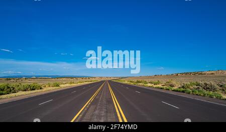Vista laterale strada asfaltata nel soleggiato giorno d'estate. Monument Valley Road. Foto Stock