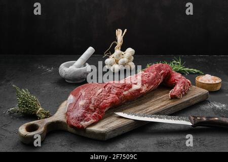 Filetto di manzo crudo a tre punte su tagliere di legno Foto Stock