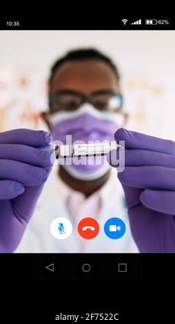 Da sotto contenuto portava imprenditore maschile in abbigliamento formale guardando via mentre si ha conversazione telefonica vicino moderno edificio a più piani su strada di Foto Stock