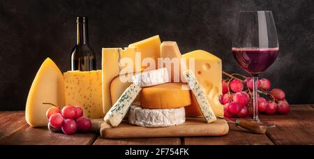 Panorama del formaggio e del vino su sfondo nero. Molti formaggi diversi Foto Stock