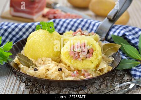 Gnocchi di patate ripieni di pancetta altoatesina e serviti con crauti in una padella di ferro Foto Stock