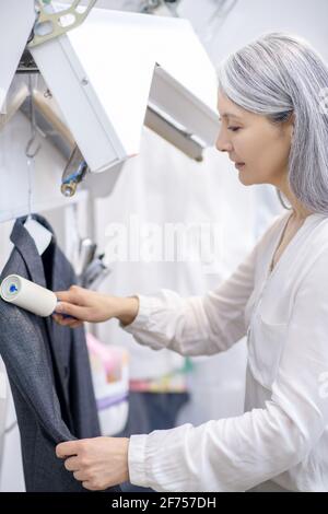 Giubbotto per la pulizia della donna gioiosa con rullo speciale Foto Stock