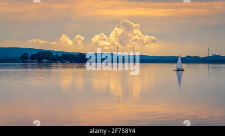 Serata allo Steinhuder Meer con una barca a vela e l'isola di Wilhelmstein sullo sfondo, visto a Steinhude, bassa Sassonia, Germania Foto Stock