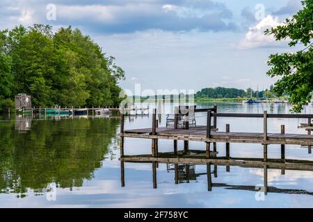 Un molo con due sedie sulla riva dello Steinhuder Meer con vista sull'isola balneare di Steinhude, bassa Sassonia, Germania Foto Stock