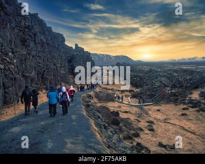 Turisti o escursionisti a piedi lungo la strada di campagna in Islanda Foto Stock