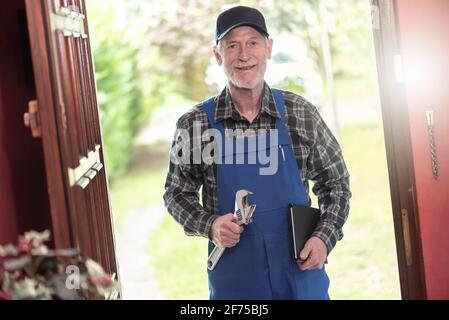 Ritratto di riparatore in piedi all'ingresso di una casa Foto Stock