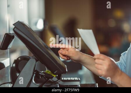 Processo di stampa della fattura per un cliente, processore di carte di credito, stampante per ricevute con bolletta della spesa cartacea e monitor touchscreen, POS Foto Stock