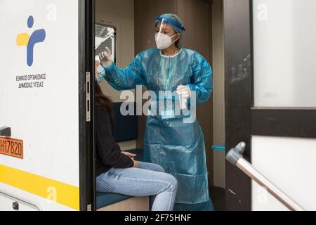 05 aprile 2021, Grecia, Athen: Un operatore sanitario prende un bastoncino da una donna presso una stazione mobile di test Corona dell'Organizzazione nazionale della sanità pubblica (EODY) in Ermou Street, la più grande strada commerciale di Atene. Da lunedì 05.04.2021, i negozi di gran parte della Grecia potranno riaprirsi dopo settimane di blocco durante la pandemia di Corona. Tuttavia, entrare nei negozi è soggetto a diverse condizioni. Foto: Socrate Baltagiannis/dpa Foto Stock