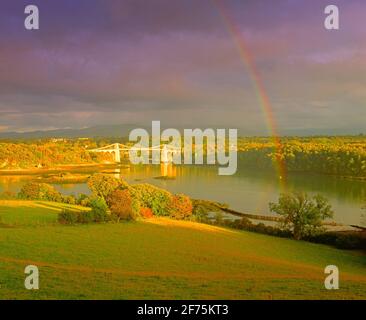 Regno Unito, Galles, Ponte Menai sullo stretto di Menai, autunno, tramonto, con arcobaleno Foto Stock