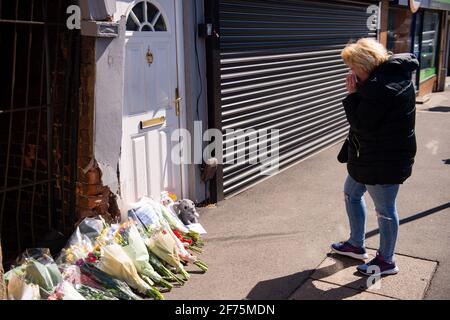 Una donna appare sconvolta dopo aver posato fiori sulla scena di High Street, Brownhills, vicino a Walsall, nelle West Midlands, dove un bambino di due settimane in un pRAM è stato colpito da una vettura BMW intorno alle 16:00 la domenica di Pasqua. West Midlands Police ha detto che il bambino è stato portato in ospedale, ma non si poteva fare nulla per salvarlo. Data immagine: Lunedì 5 aprile 2021. Foto Stock