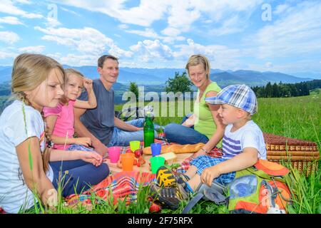 Una giovane famiglia che si gode un pic-nic in montagna in un'escursione vicino a Sulzberg nel Bregenzerwald. Foto Stock