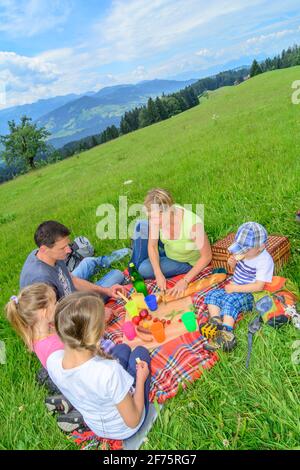 Una giovane famiglia che si gode un pic-nic in montagna in un'escursione vicino a Sulzberg nel Bregenzerwald. Foto Stock