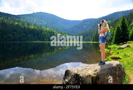 Fotografo della natura scattare foto con la fotocamera DSLR moraine lago Kleiner Arbersee nel parco nazionale della foresta bavarese. Germania. Foto Stock