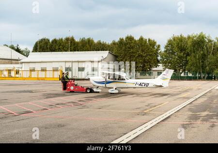 Venegono inferiore, Varese, Italia - 02 settembre 2017: I lavoratori che trasferiscono l'aereo Cessna 172 SP all'hangar, è la flotta dell'Aero Club di Varese. Foto Stock