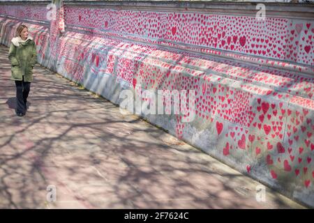 Una donna vede il National Covid Memorial Wall, a Westminster, nel centro di Londra, che commemora le persone uccise nel Regno Unito dal coronavirus. Data immagine: Lunedì 5 aprile 2021. Foto Stock