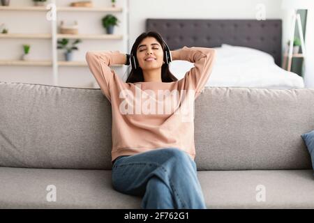 Giovane donna ascoltando la musica che indossano le cuffie Foto Stock