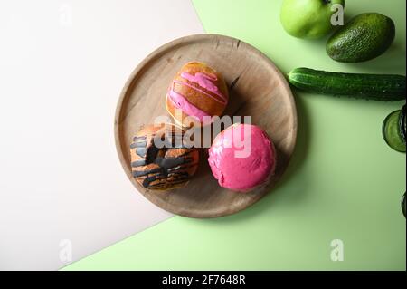 Verdure verdi s vs ciambelle. Problemi alimentari e di salute malsani. Foto di alta qualità Foto Stock