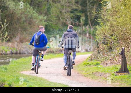 Kidderminster, Regno Unito. 5 aprile 2021. Tempo in Gran Bretagna: Due amici in bicicletta lungo un canale del Worcestershire su una luminosa, ma piuttosto fresco, festa della Banca di Pasqua. Credit: Lee Hudson/Alamy Live News Foto Stock