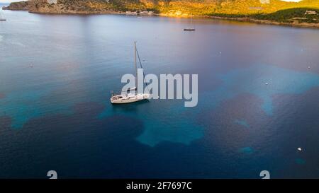 Vista aerea del drone di una barca a vela ancorata in una baia dell'isola di Cabrera nell'arcipelago delle Isole Baleari, Spagna Foto Stock