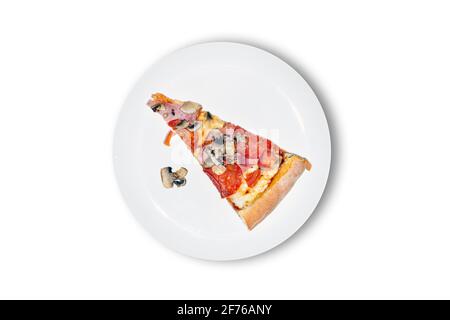 Fetta di pizza calda di campagna su piatto bianco primo piano. Vista dall'alto. Un delizioso prosciutto, pomodori, peperone, funghi pizza. Foto Stock