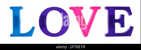 Word Love è foderato con lettere di plastica multicolore su magneti, isolato su sfondo bianco. Foto Stock