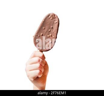 La mano di un bambino tiene un gelato al cioccolato su un bastone, un papsiclo con noci, isolato su uno sfondo bianco. Foto Stock