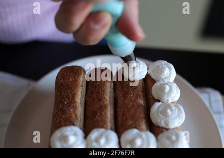 Tiramisù, dessert italiano. Donna che prepara torta tiramisù. Primo piano. Foto Stock