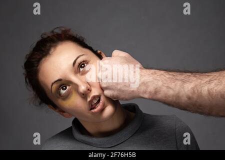 Il pugno di un uomo colpisce una donna in faccia. Conflitto interpersonale e violenza in famiglia. Foto Stock