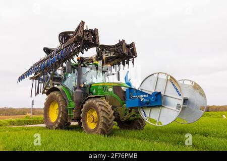 Trattore con barra di dribbling con spanditore di liquame Tramspread ripiegato e riavvolgitore per tubi montato, utilizzato per applicare la pasta ai campi. Hertfordshire. REGNO UNITO Foto Stock