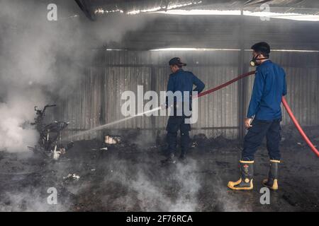 Kendari, Indonesia. 05 aprile 2021. I vigili del fuoco vedevano spegnere alcuni degli articoli ancora in fiamme nel warehouse.Today un incendio scoppiò e ingolfò un magazzino a Kendari. Secondo i testimoni oculari, l'incendio è stato innescato da un corto circuito di elettricità che ha catturato fiamme dopo aver colpito una bombola di gas e una motocicletta all'interno del magazzino. (Foto di Andry Denisah/SOPA Images/Sipa USA) Credit: Sipa USA/Alamy Live News Foto Stock