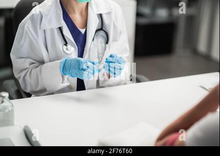 L'infermiere si prepara a iniettare il farmaco nella vena del paziente, tenendo una siringa con il farmaco nelle mani. Foto Stock